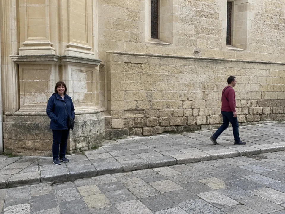 Brushed: the person and their shadow on the pavement.